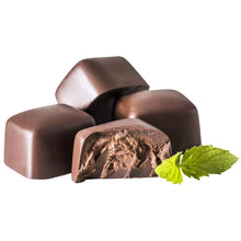 Milk chocolate mint truffles with cocoa coating and green mint leaves