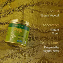 VAHDAM moringa powder jar partially surrounded by green powder