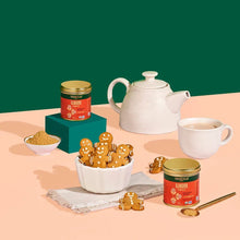 VAHDAM ginger powder jar beside teapot, cup, and gingerbread cookies