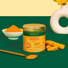 Turmeric powder jar with bowl of powder and scattered turmeric roots