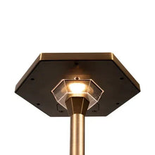 Underside of solar path light head with glowing center and brass support