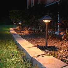 Outdoor solar path light on brass stake with illuminated lamp head