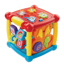 Busy learners activity cube toy with red top, yellow frame, blue feet, and side shape blocks