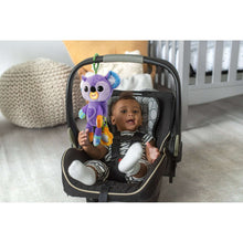 Baby in stroller with purple koala clip-on plush toy, orange ring, and green hook