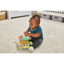 Toddler sitting on carpet with baby driver toy, looking at colorful button panel