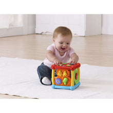 Colorful plastic activity cube toy with red top, ladybug side panel, and red wheel details