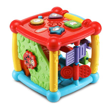 Colorful plastic activity cube toy with red top, green texture side, and purple blocks