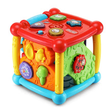 Colorful plastic activity cube toy with red top and ladybug panel on green side