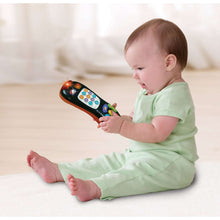 Orange and black number-counting remote toy held by baby, colorful keypad buttons