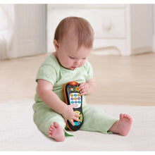 Baby playing with orange and black number-counting remote toy with colorful buttons