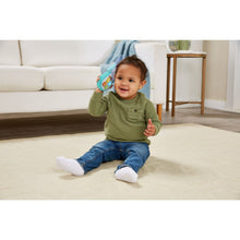 Baby sitting and holding plush hippo soft phone toy with dangling buttons