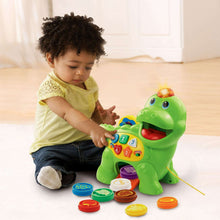 Green dinosaur learning toy with counting buttons, mouth opening, and colorful food discs