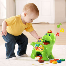 Green dinosaur learning toy with mouth opening, counting panel, and child feeding accessories