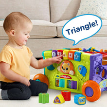 Green activity wagon toy with numbered buttons, colorful doors, and sorting cubes