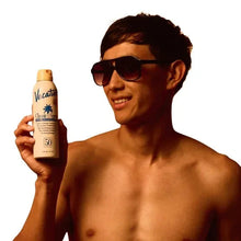 SPF 50 sunscreen spray bottle in hand with sunglasses and yellow pump