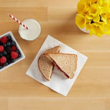 White paper napkins under sliced bread on a wooden table