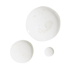 Brightening serum swatch circles with glossy drops on white surface