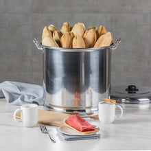 Aluminum steamer pot filled with corn husks on a countertop