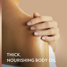 Thick nourishing body oil on skin, hand applying product to shoulder area