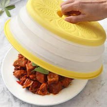 Yellow collapsible microwave splatter cover with vented top held over food