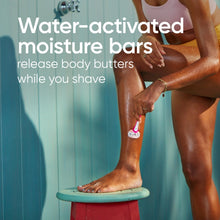 Water-activated moisture bar razor held while shaving, pink and white 3-blade