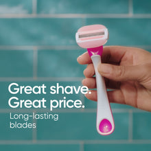 Pink and white 3-blade disposable razor held in hand