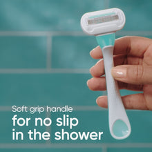 Women’s blue disposable razor with soft-grip handle, held by fingers