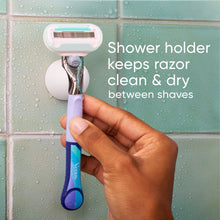 Razor in hand inserted into shower holder with blades facing up