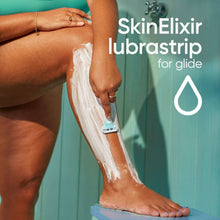 Women’s disposable razor gliding over shaving cream on leg, light blue handle