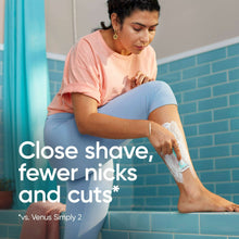 Women’s disposable razor shaving cream on leg, light blue handle
