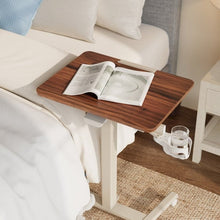 Versalift mobile desk beside a bed, with a wood-grain top and attached cup holder