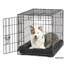 Black wire dog crate with leak-proof tray and door latch, dog resting inside.