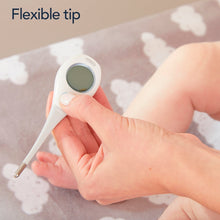 White digital thermometer with flexible tip held in hand, green LCD visible