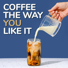 French roast iced coffee in a clear glass with pouring pitcher and single-serve cup nearby