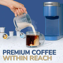 Coffee mug with dark coffee being poured, with single-serve cups and lid cups nearby