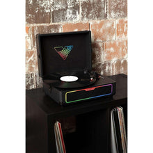 Suitcase record player on tabletop with open lid and colored light strip on speaker