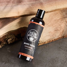 Beard wash bottle on a wooden board, black bottle with orange accents and Sandalwood