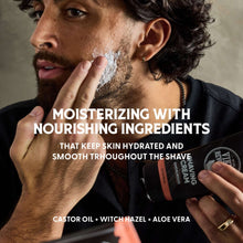 Shaving cream applied to a man’s cheek with a shaving tube held nearby