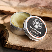 Beard balm jar with pale balm swirl, open lid tin on wooden surface