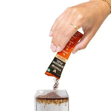 Single VitaCup Shroom Fuel mushroom drink mix stick held above jar of mix