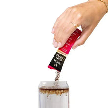 Hand pouring Slim coffee stick granules from a sachet into a jar