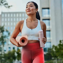Woman holding Slim coffee sticks and a drink bottle outdoors