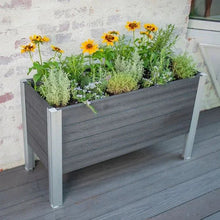Elevated garden planter with dark gray wooden sides and mixed flowers