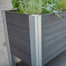 Corner view of dark gray wooden elevated planter with light gray support posts