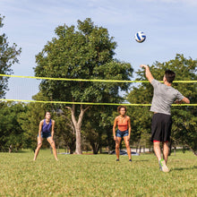 Adjustable volleyball and badminton net set with volleyball and height poles outdoors