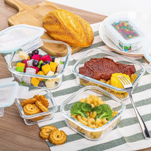 Glass food storage containers with clear lids and turquoise trim, holding prepared meals