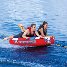 Two-person towable water tube on choppy water, red and blue; two people riding.