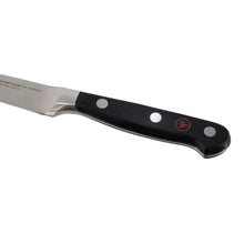 Stainless steel knife with black handle and red emblem, side angle view