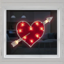 Lighted heart with crossed arrows displayed on window