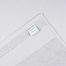 White waffle bath towel with woven texture and brand label tag